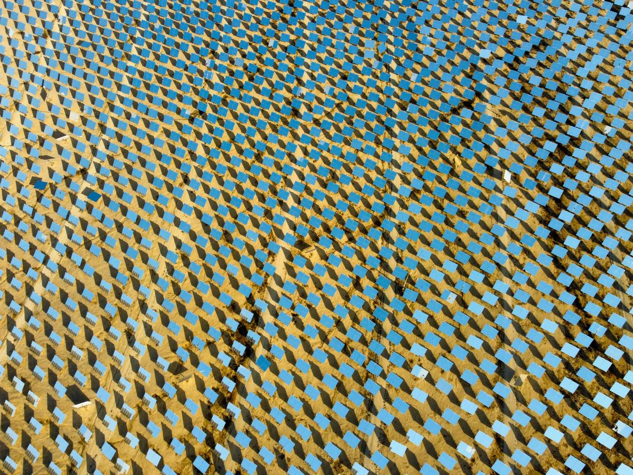 Vista aèria d'un camp massiu d'heliostats i espalls solars en una gran planta d'energia solar.